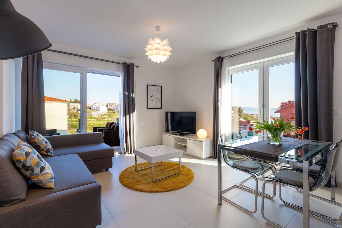 Apartamento família, 2 quartos, sacada, vista para o mar | Área de estar | TV de tela plana