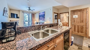 A modern kitchen with granite countertops, stainless steel sinks, and a coffee maker. - Highland Greens Lodge 210 1 Bedroom Condo by RedAwning (Breckenridge)