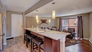A modern kitchen with a central island, bar stools, and pendant lighting. - Peak 8 Ge E35 2 Bedroom Condo by RedAwning (Breckenridge)