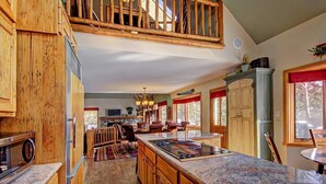 A spacious kitchen with wooden cabinets, a large island, and a dining area with chairs.