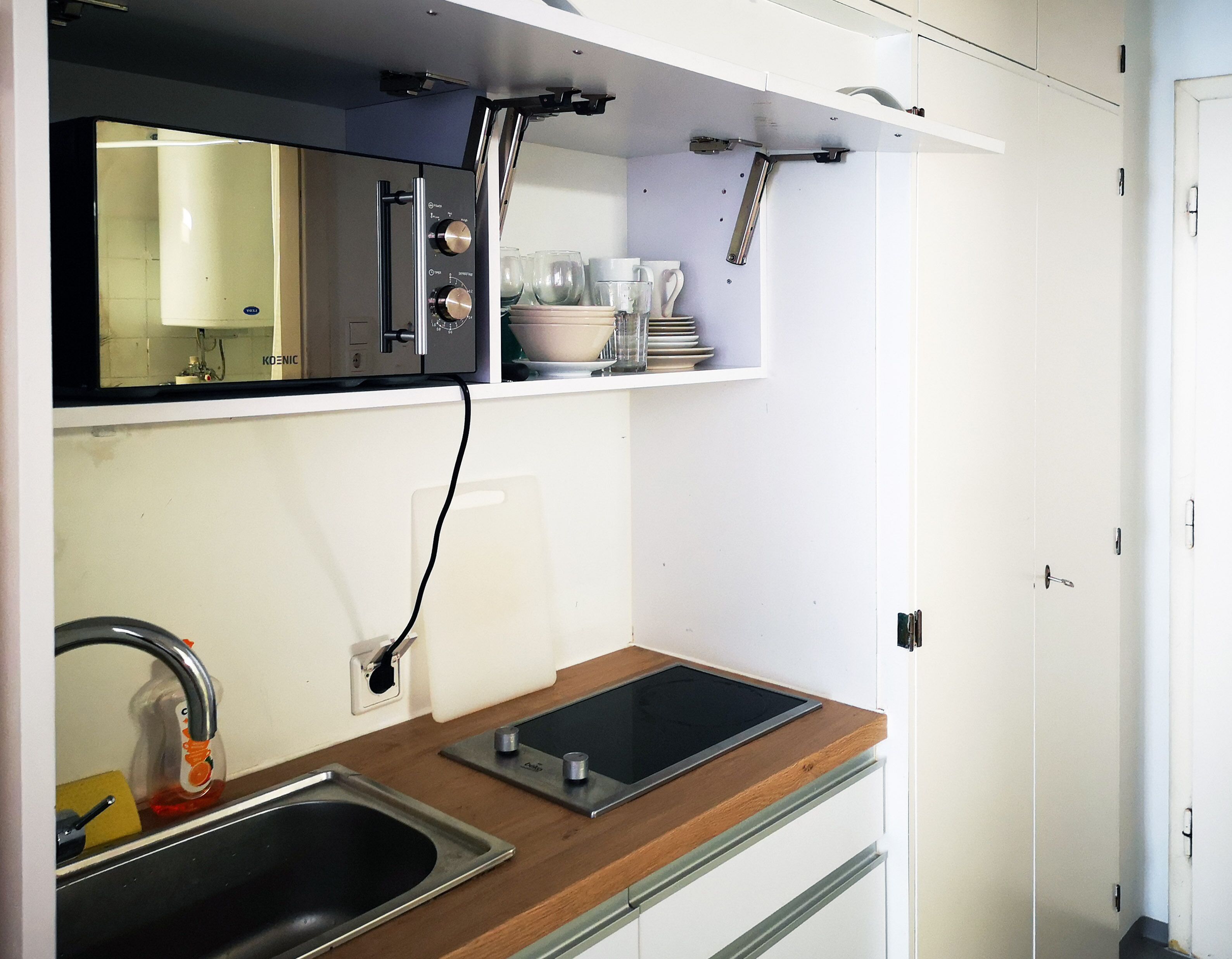 A compact kitchen with a sink, a stove, and a countertop.