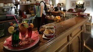 Un espace bar proposant une variété de boissons et d’en-cas, notamment des cocktails colorés et de petites portions de nourriture.