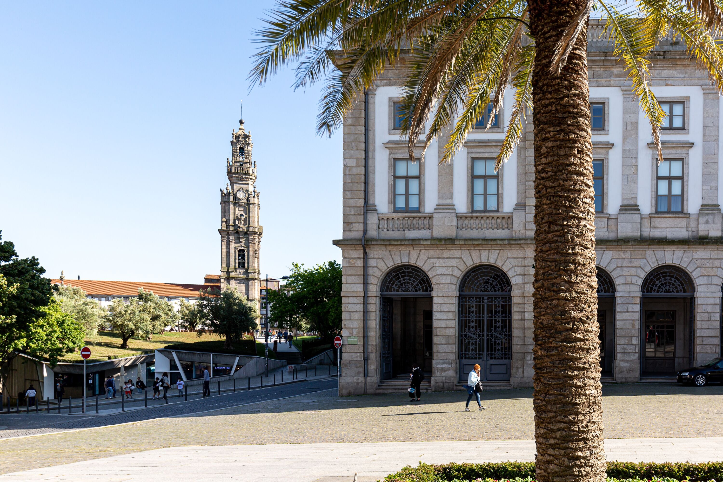 Een historisch gebouw met grote gewelfde ramen en een opvallende klokkentoren op de achtergrond.