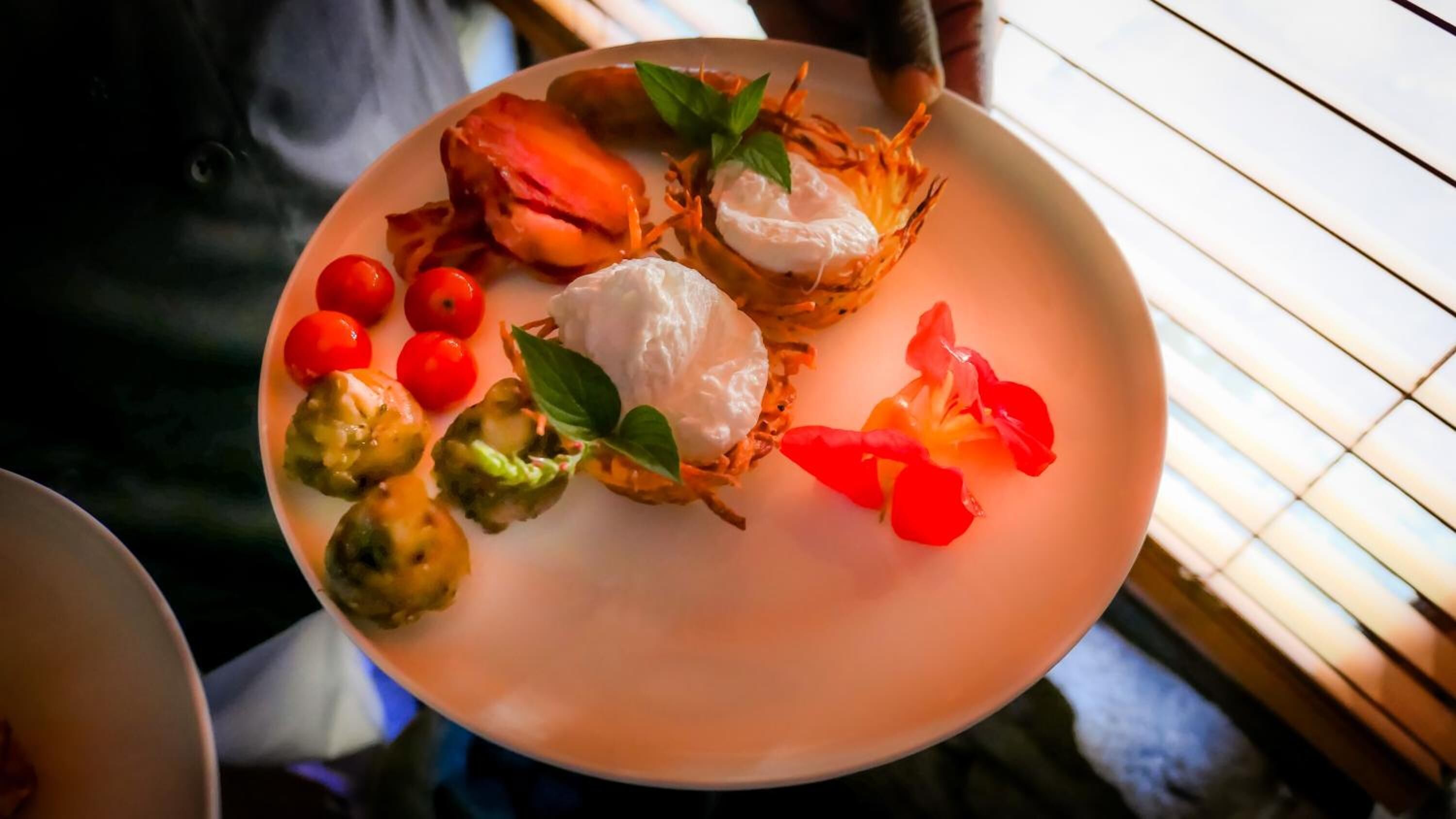 A plate with food items including shrimp, cherry tomatoes, and a garnish.