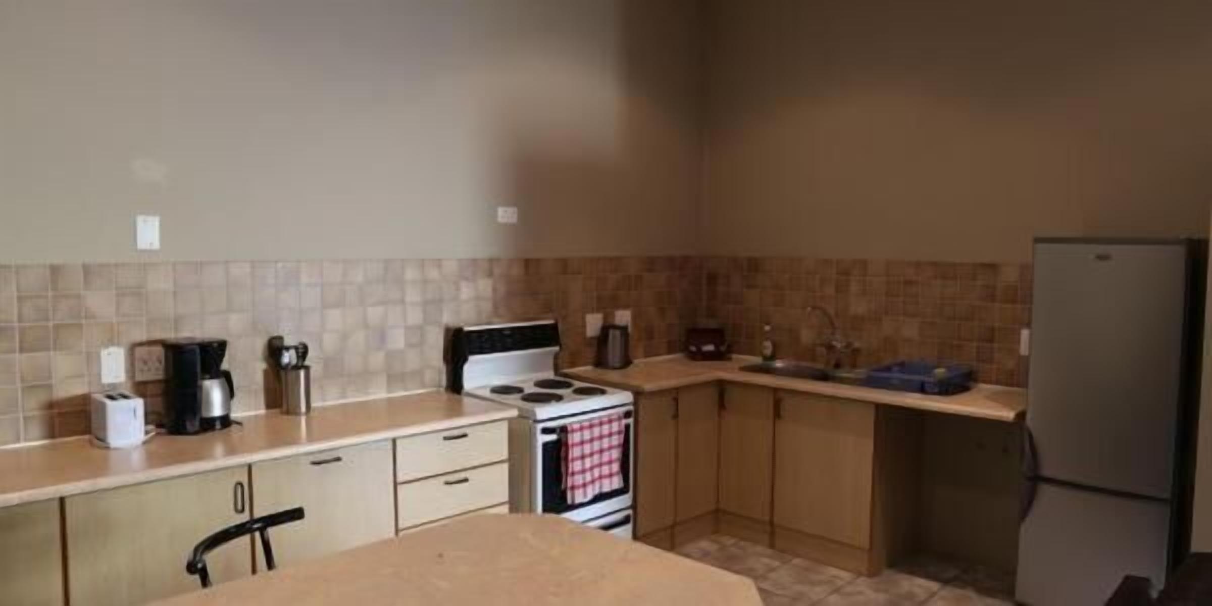 A compact kitchen with a stove, sink, and basic appliances.