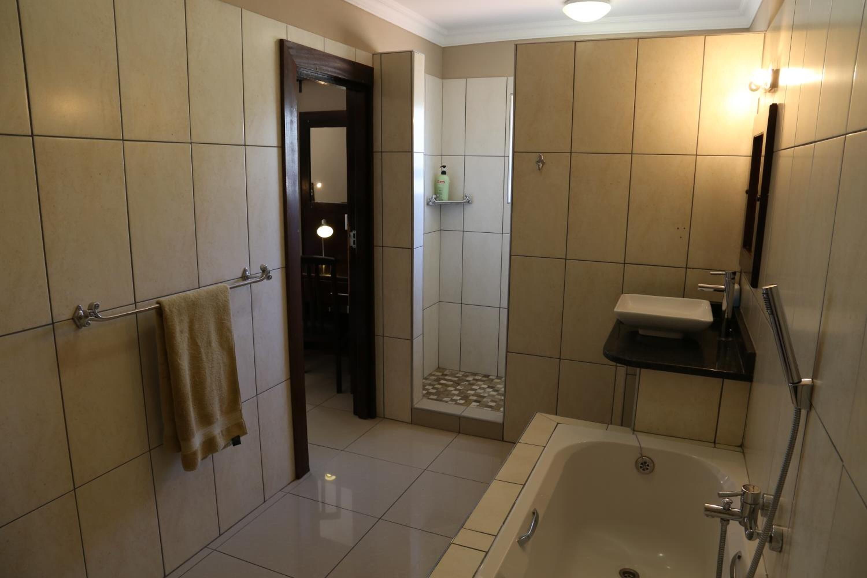 Un baño moderno con bañera, lavamanos y zona de ducha.