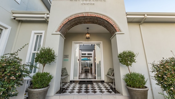 L’entrée du Waterstone Lodge, avec son sol à carreaux, une arche et des plantes en pot.