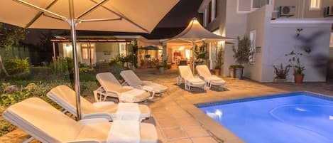 Piscine extérieure, parasols de plage, chaises longues