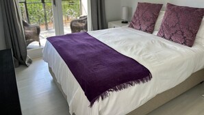A bedroom with a bed, a purple throw blanket, and two matching pillows. - Lemon Tree Cottage (Franschhoek)