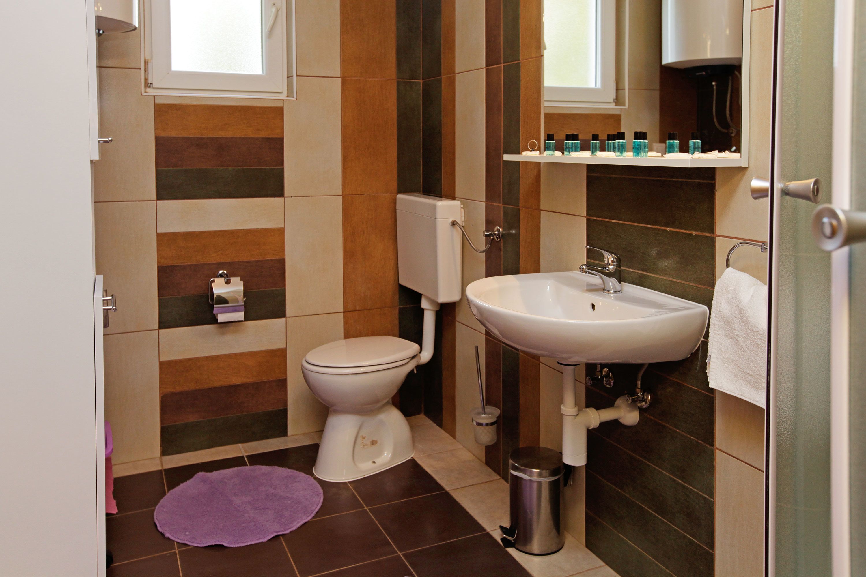 A small bathroom with a toilet, sink, and a trash can.