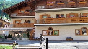 A multi-story building with wooden balconies, flower boxes, and a traditional architectural style.