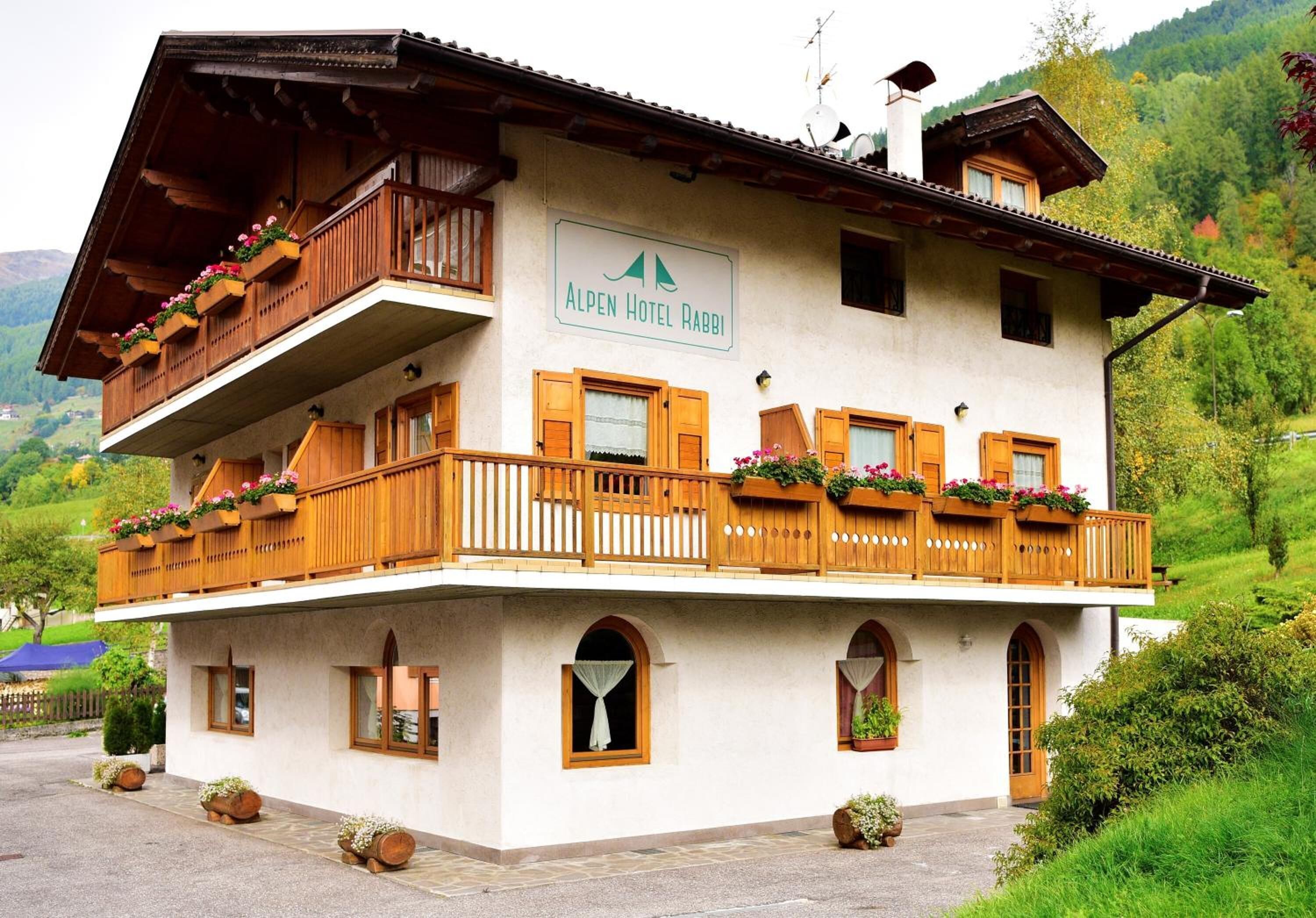 A two-story building with a balcony, wooden railings, and flower boxes.