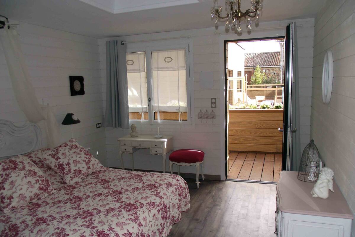 Une chambre à coucher comprenant un lit, un bureau, une chaise et un petit meuble de rangement.