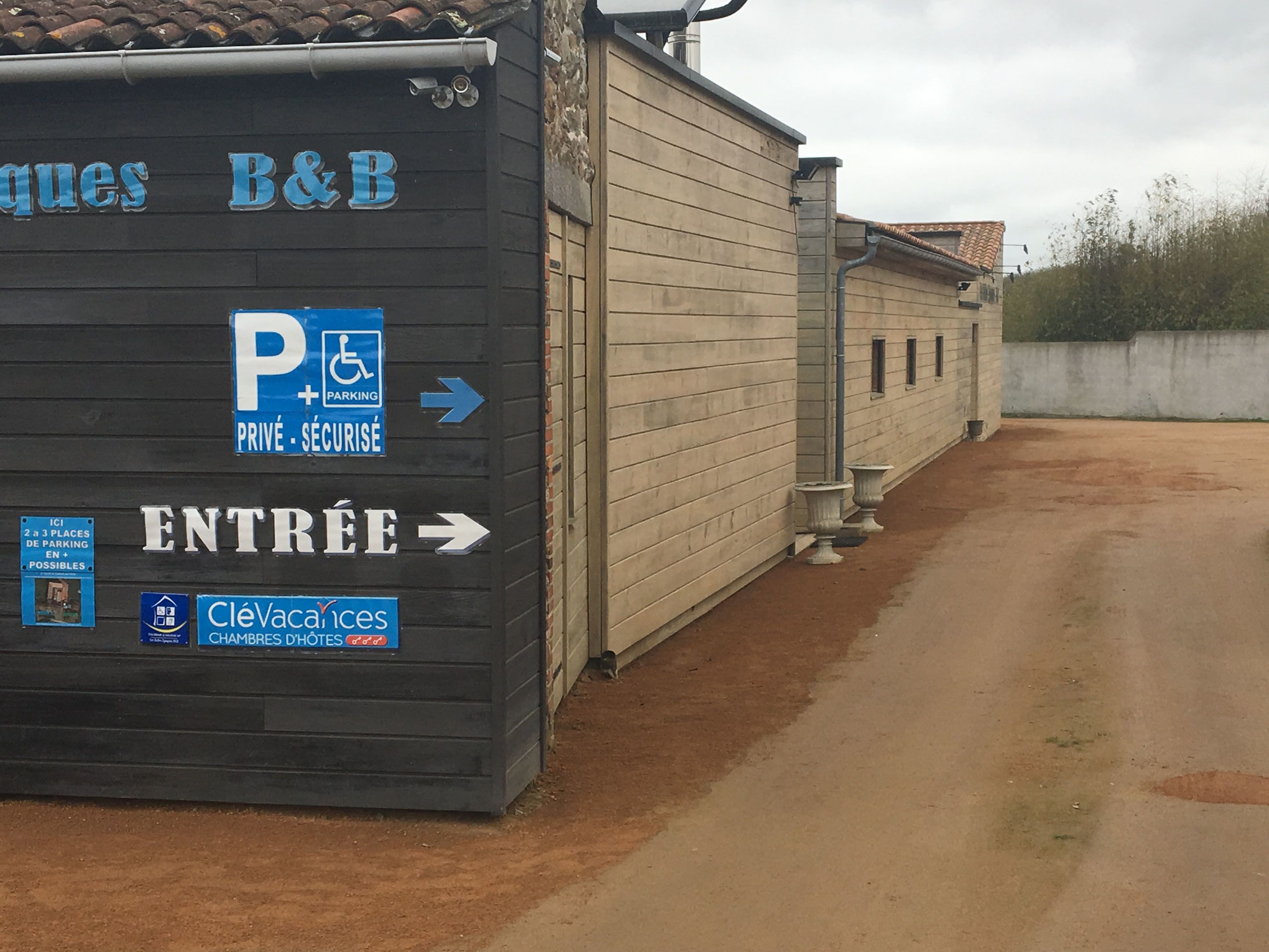 Un bâtiment avec une enseigne indiquant un espace de stationnement et une entrée.