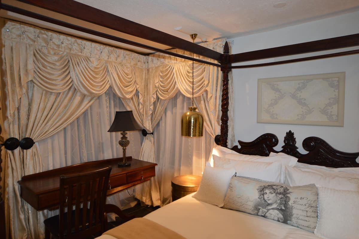 Un dormitorio con una cama de madera, un escritorio y una silla.