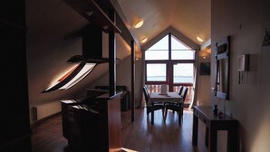 A modern interior with a dining area, large windows, and a view of the outdoors. - Hótel Hafnarfjall (Hvalfjarðarsveit)