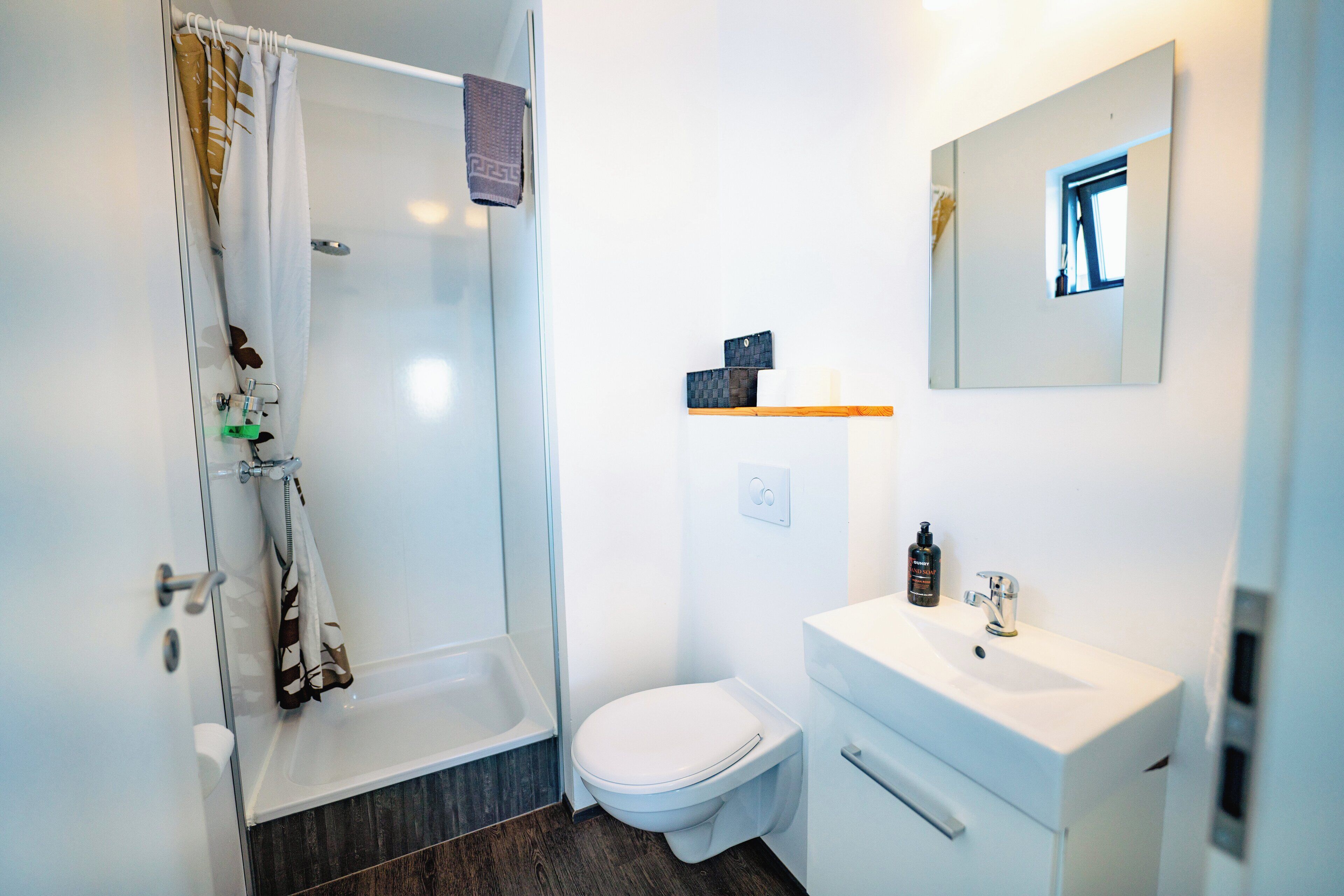 A bathroom with a shower, toilet, and sink.