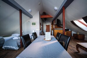 A room with a dining table, chairs, a bed, and a kitchenette. - Hótel Hafnarfjall (Hvalfjarðarsveit)