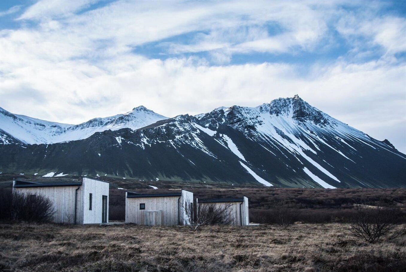 A remote, mountainous landscape with a small, rustic building with a single door and a small window.