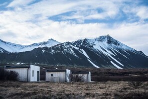 A remote, mountainous landscape with a small, rustic building with a single door and a small window. - Hótel Hafnarfjall (Hvalfjarðarsveit)