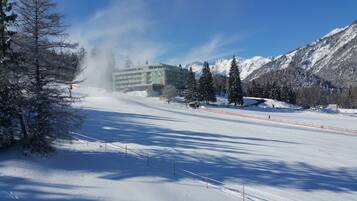 Una pista de esquí cubierta de nieve con un edificio al fondo.