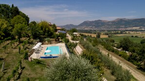 Un espace piscine offrant une vue dégagée sur le paysage environnant, notamment sur les arbres et les collines au loin.