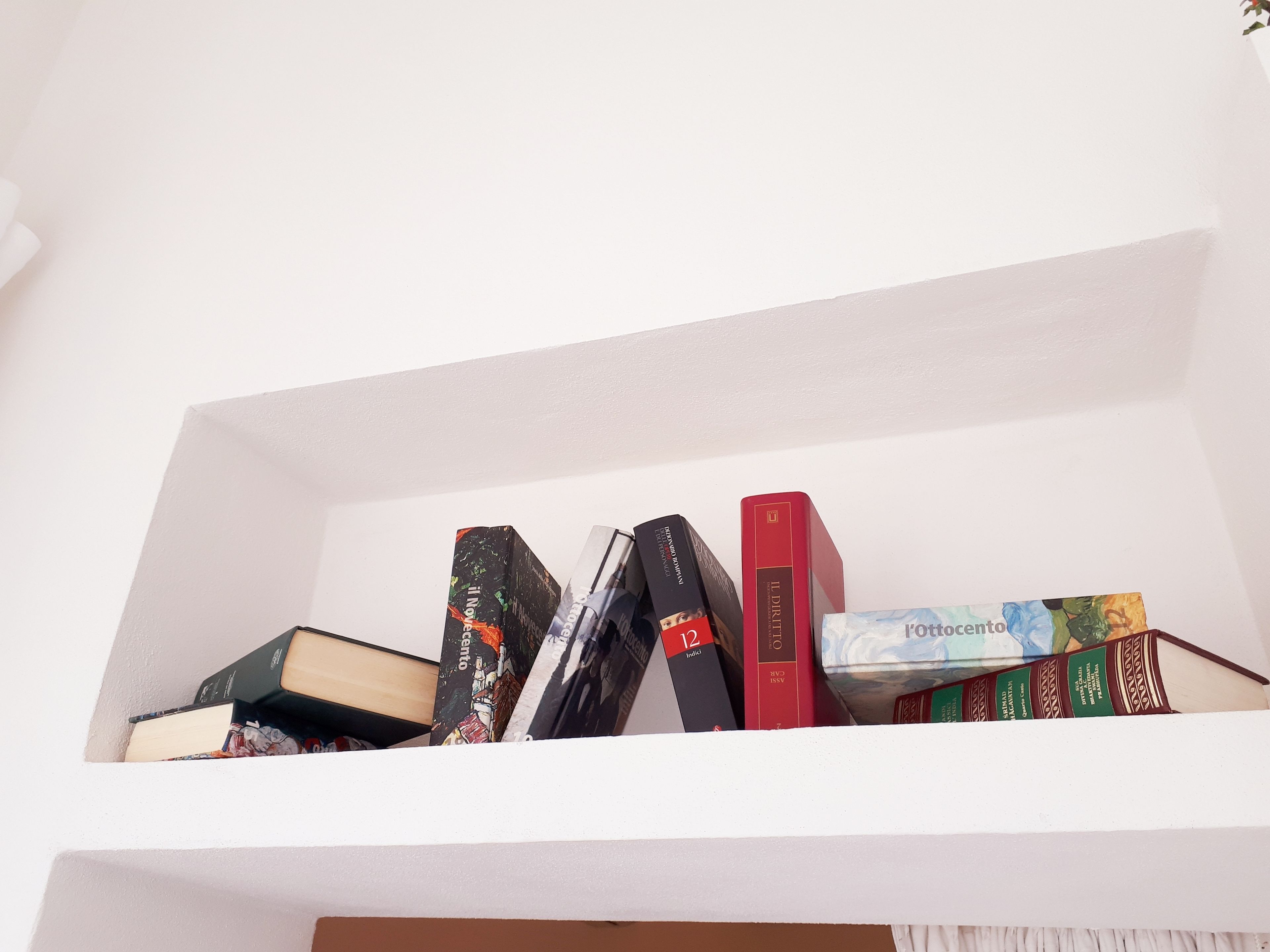 A bookshelf with various books and a magazine.