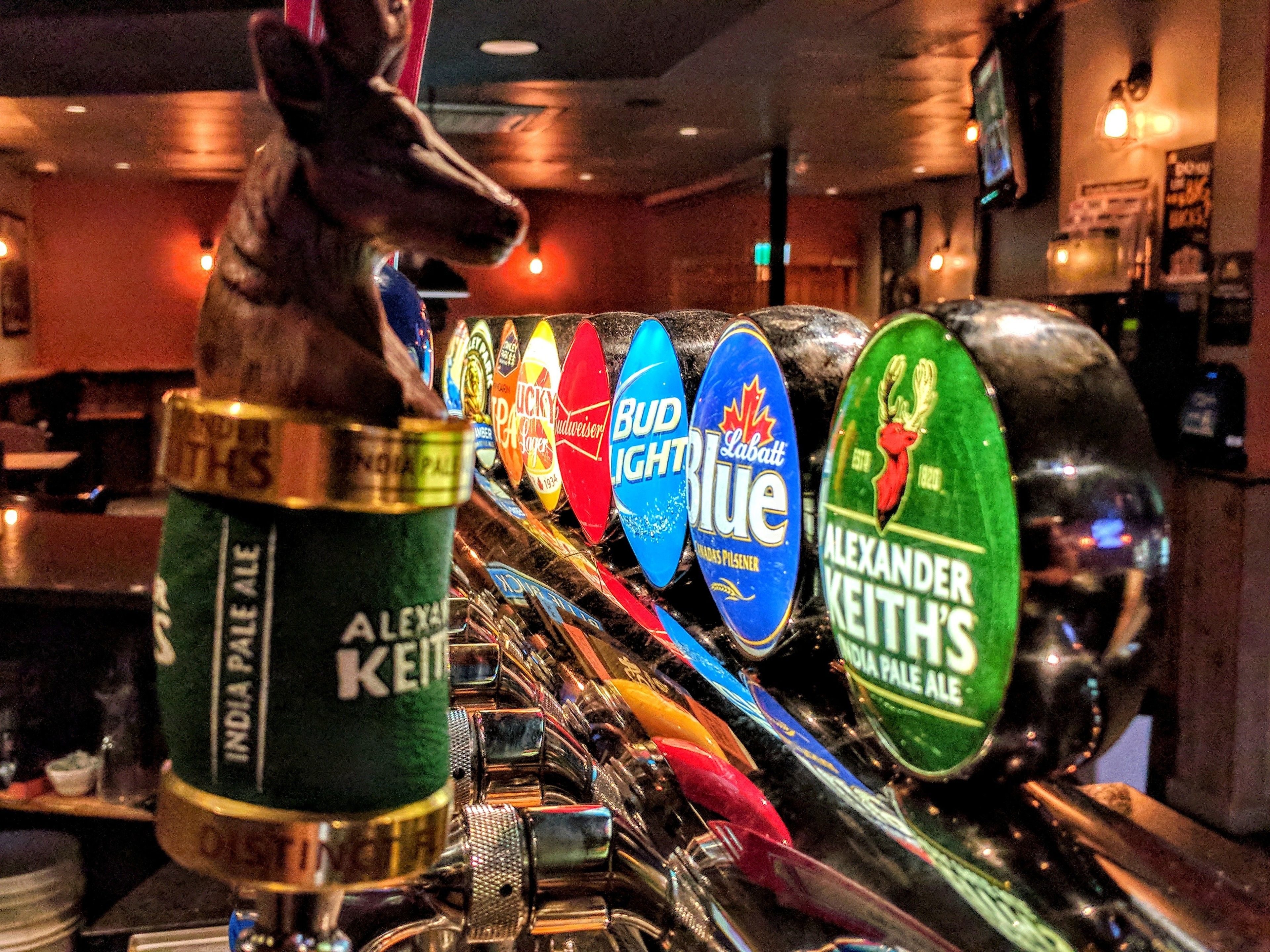 A bar tap with various beer labels, including Bud Light and Alexander Keith's.