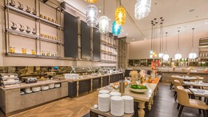 A buffet area with a variety of food items and a seating area with tables and chairs. - Sheraton Los Angeles San Gabriel (San Gabriel)