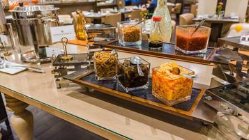 A buffet setup with various food items and condiments.