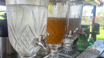 A bar area with multiple glass dispensers, one of which contains a brown beverage.