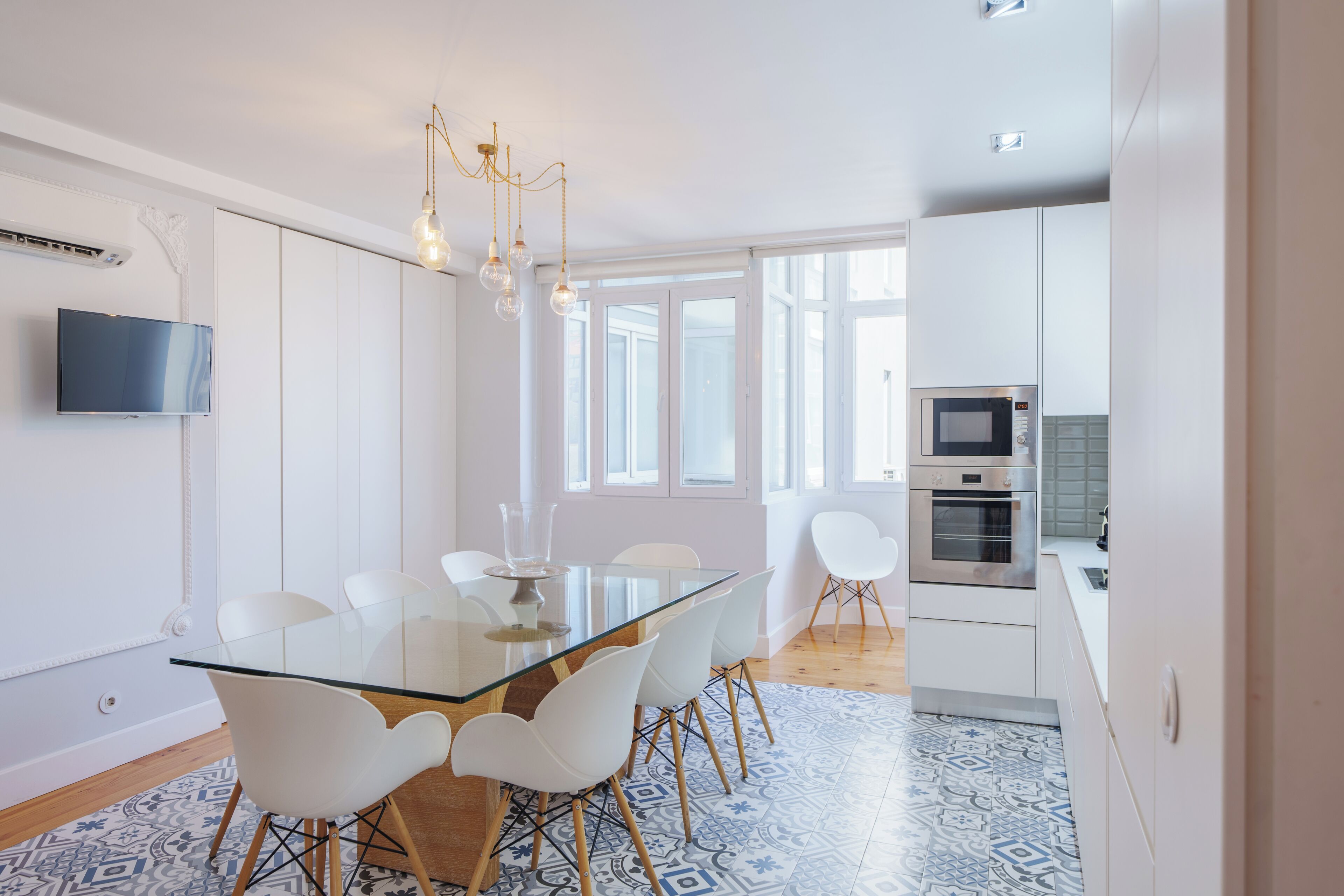 A modern kitchen with white cabinets, a built-in oven, and a microwave.