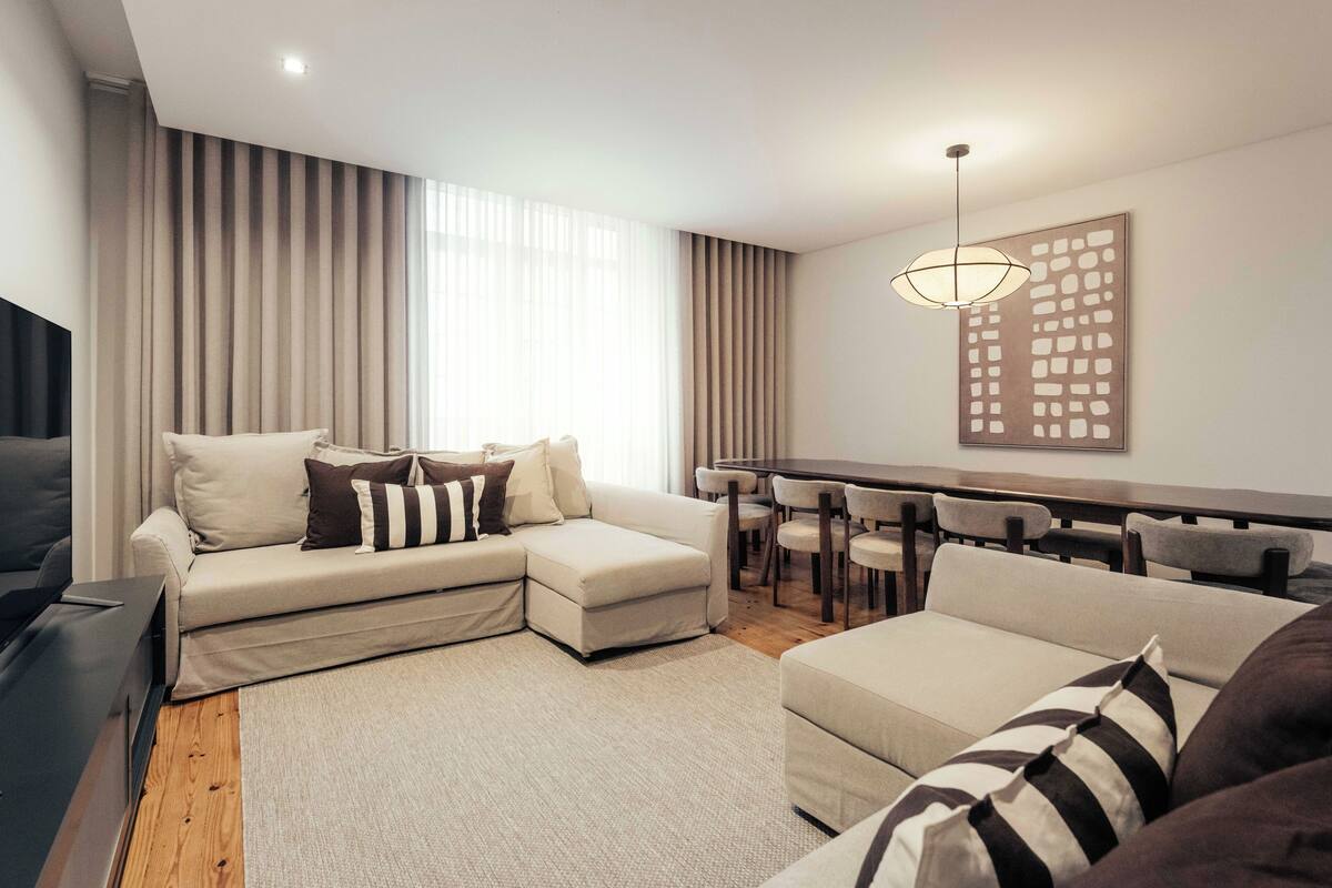 Ein modernes Wohnzimmer mit einem Ecksofa, einem Esstisch und Stühlen.
