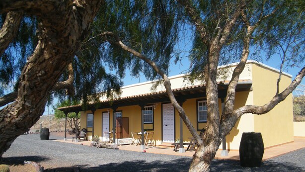 A building with a yellow facade, multiple windows, and a door. - SAN JOSÉ RURAL HOUSE  (Yaco)