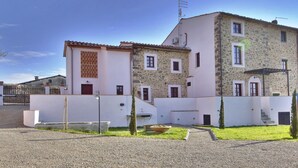 Un bâtiment à deux étages, doté d’une façade en pierre et d’une partie supérieure blanche.