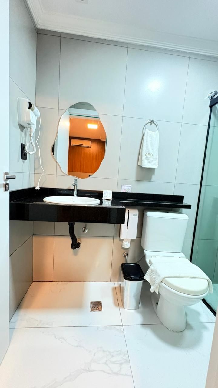 Une salle de bain moderne avec un plan de toilette noir, un lavabo blanc et des toilettes blanches.