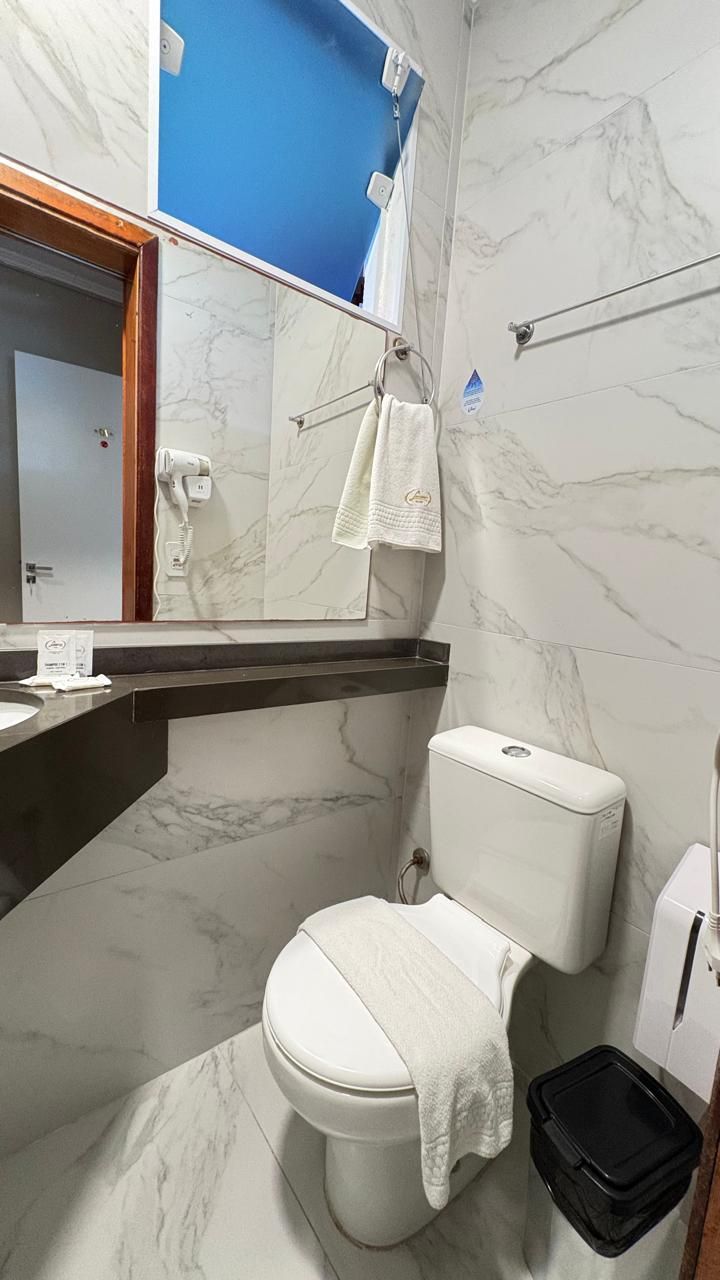 Un baño con inodoro, lavamanos y espejo.