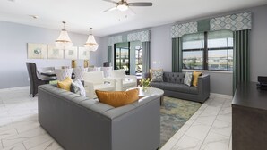 Un salon moderne avec un canapé gris, une table à manger et un ventilateur de plafond.