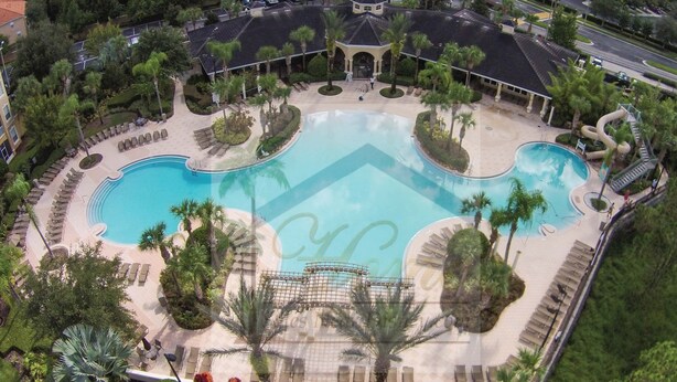 Eine Luftaufnahme eines Resorts mit mehreren Schwimmbecken, Palmen und Liegebereichen.