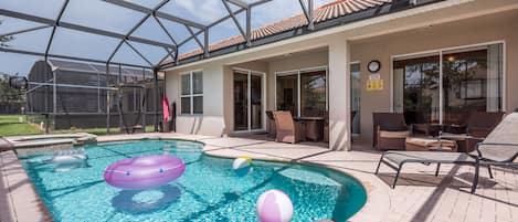 Una piscina exterior cubierta con sillones de descanso y un área de terraza.