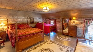 A wooden-paneled bedroom with a four-poster bed, a dresser, and a mirror. - Stay in a 200 Year Old Log Cabin with Modern Conveniences (Bland)