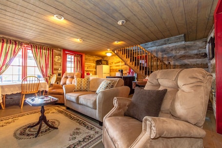 TV, fireplace, books. Stay in a 200 Year Old Log Cabin with Modern Conveniences
