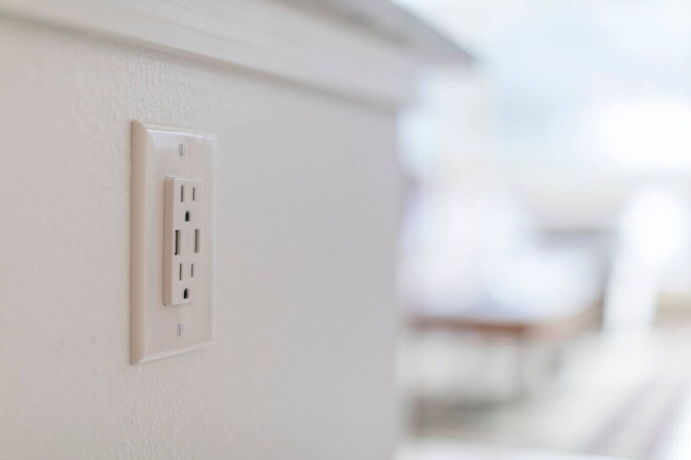 A white electrical outlet on a wall.