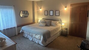 Une chambre à coucher avec un lit, des lampes de chevet, un miroir et une porte.