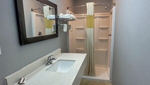 A bathroom with a white sink, mirror, and shower curtain.
