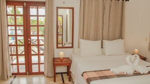 Una habitación de hotel con una cama, una mesita de noche con una lámpara, un espejo y vistas a través de un ventanal.