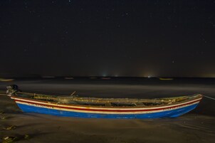 Un bote sobre una orilla arenosa de noche.