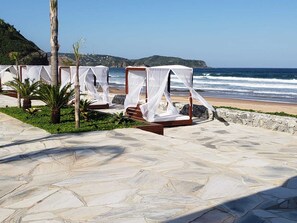A beachside lounge with outdoor seating and a view of the ocean. - Pousada Deck de Búzios (Búzios)