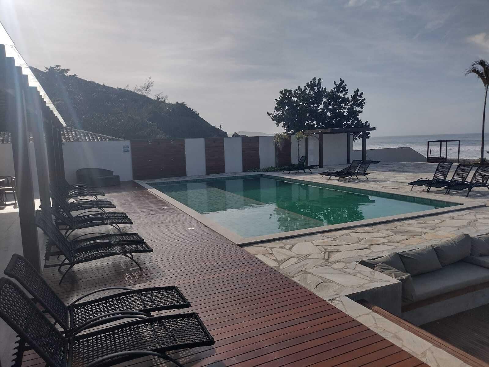 A pool area with lounge chairs and a stone deck.