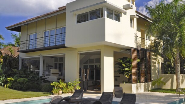 A modern two-story house with a swimming pool, outdoor seating, and a well-maintained garden. - Instyle Residences at Seahorse Ranch Villa 118 (Cabarete)